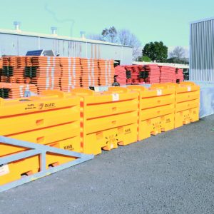 A sled end barrier and piles of different barriers in the background | Parallaxx